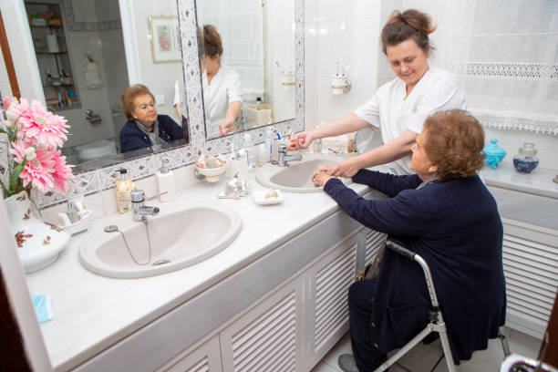 Caregiver helping a senior manage clean clothing